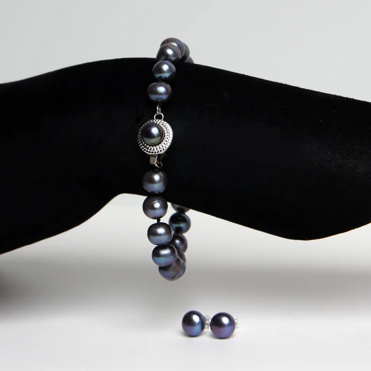 Set med pärlarmband och örhängen, svart med skimmer av midnattsblått. Äkta kultiverade sötvatten pärlor 7-8mm. Fin lyster och kvalitet.